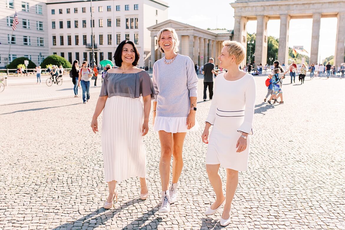 Drei Frauen laufen vor dem Brandenburger Tor Berlin