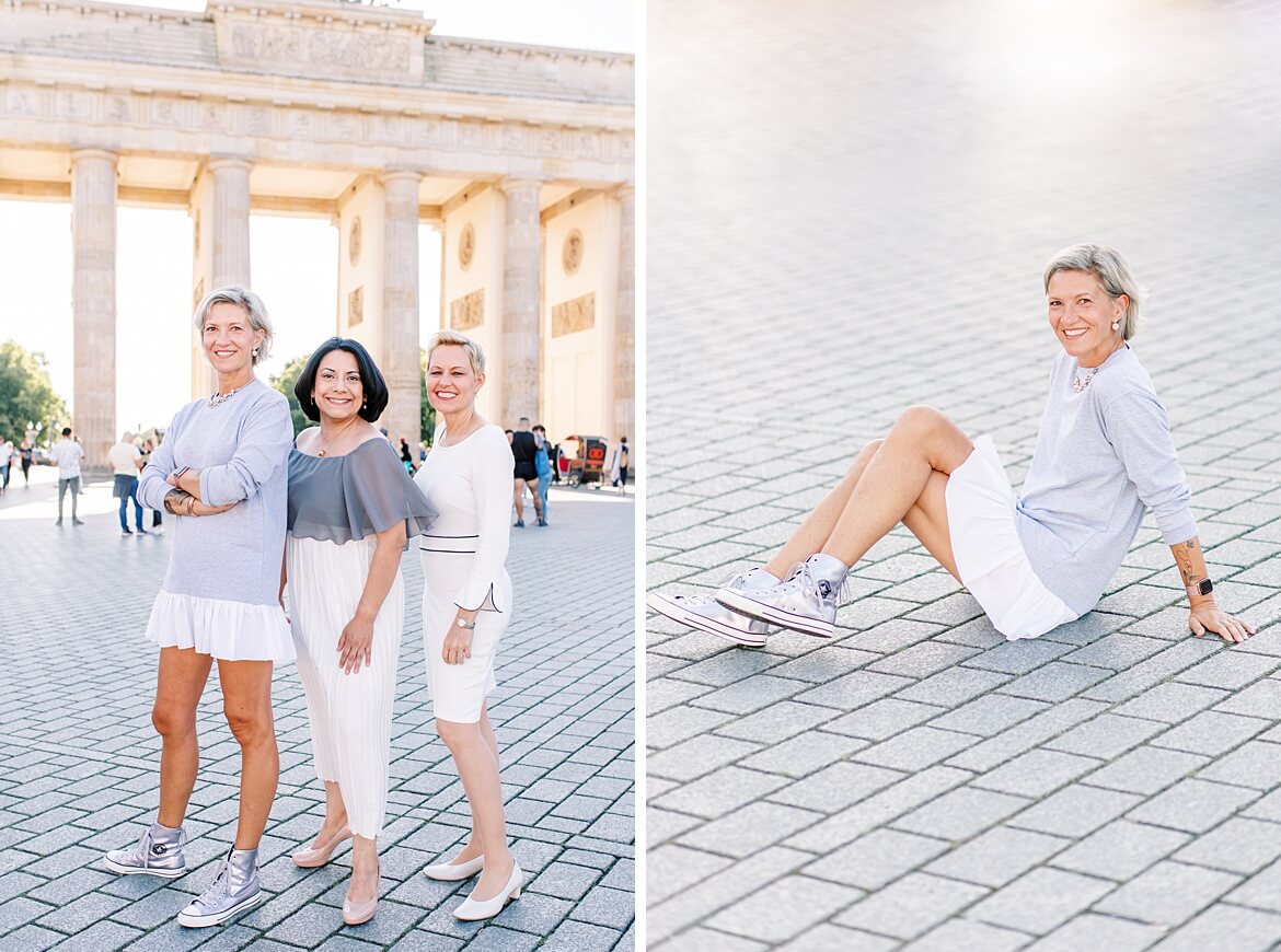 Drei Frauen stehen bzw. eine Frau sitzt vor dem Brandenburger Tor Berlin