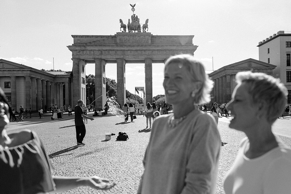 Schwarz weiß Foto von verschwommenden Frauen im Vordergrund und dem Brandenburger Tor Berlin im Hintergrund