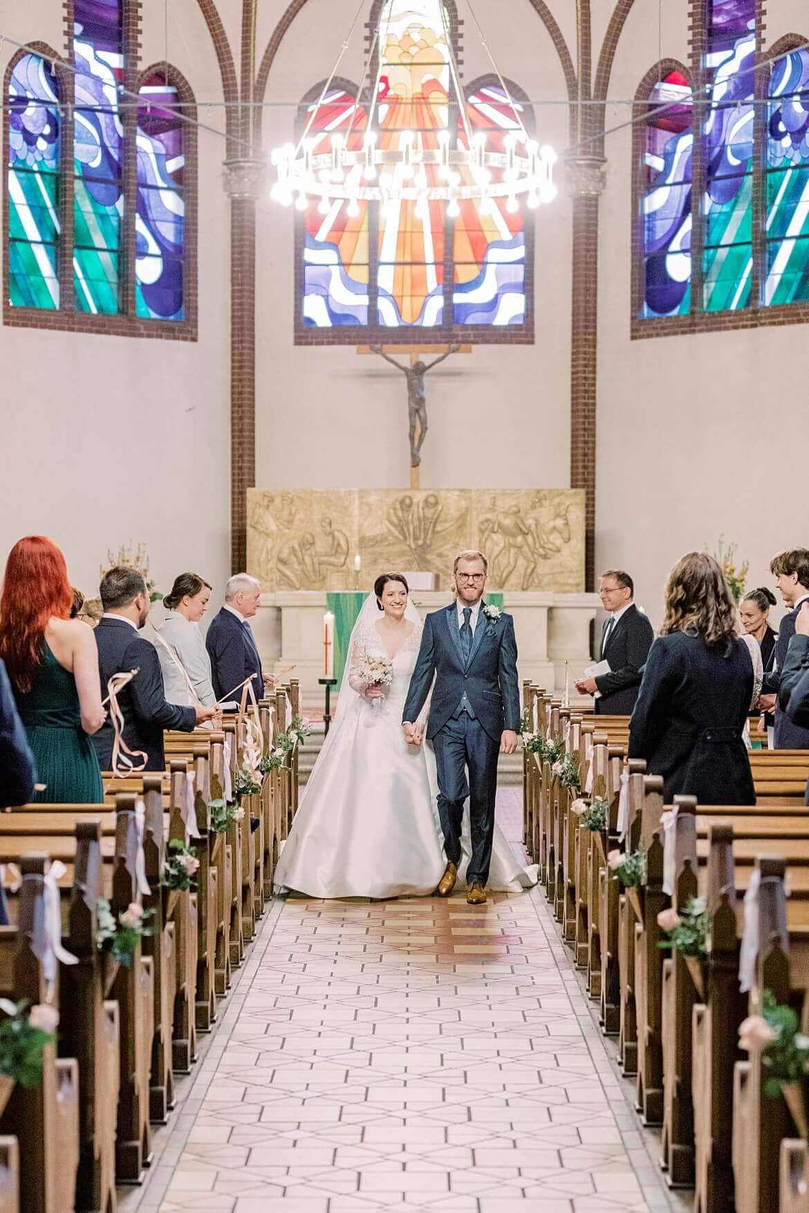 Brautpaar läuft Gang in Kirche entlang