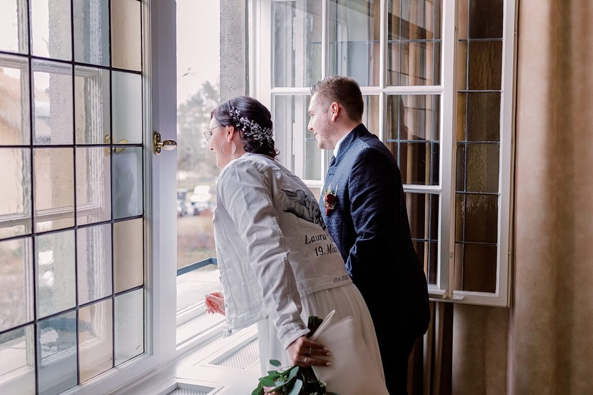 Brautpaar winkt aus Fenster im Standesamt Berlin Reinickendorf