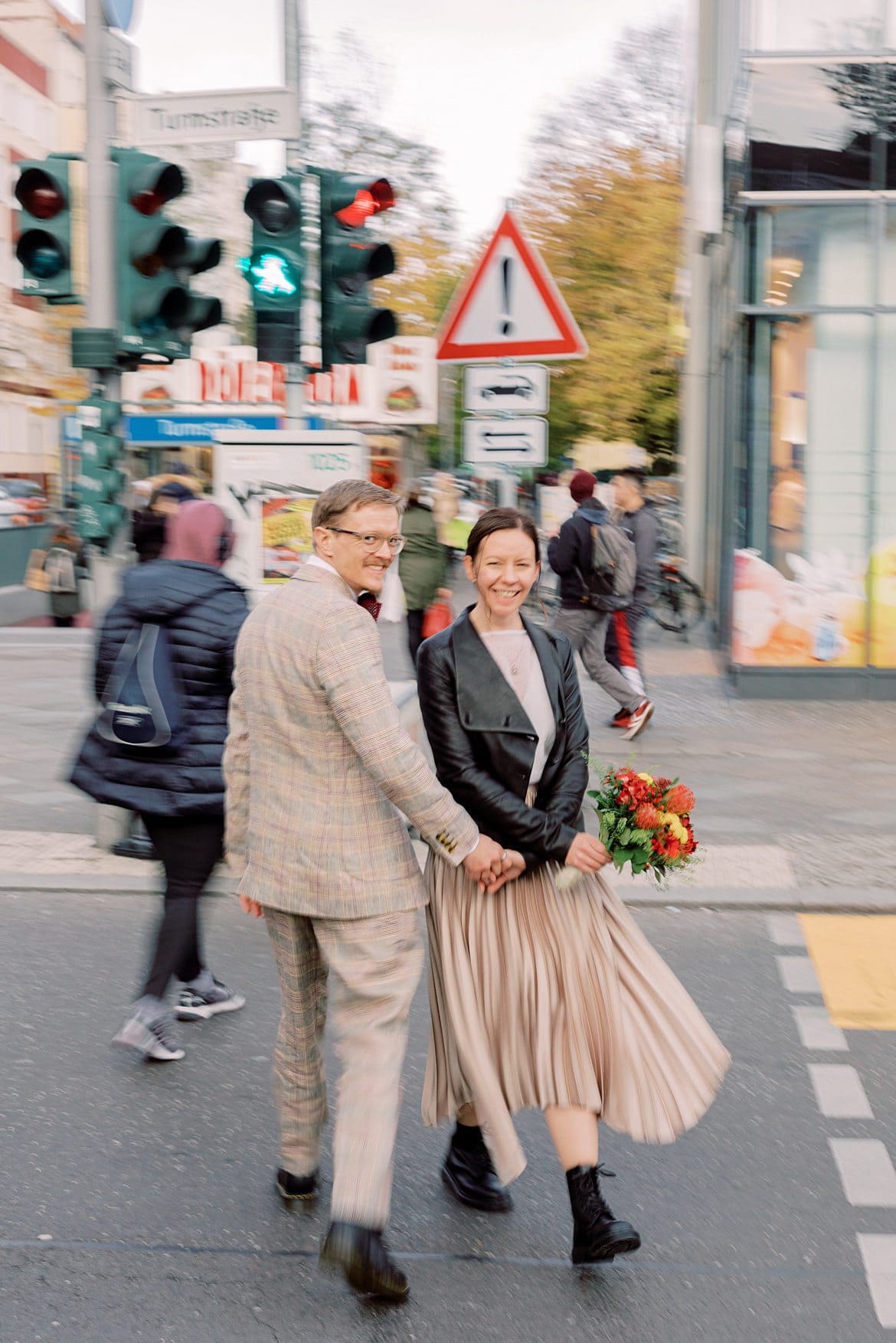 Brautpaar läuft über eine Straße