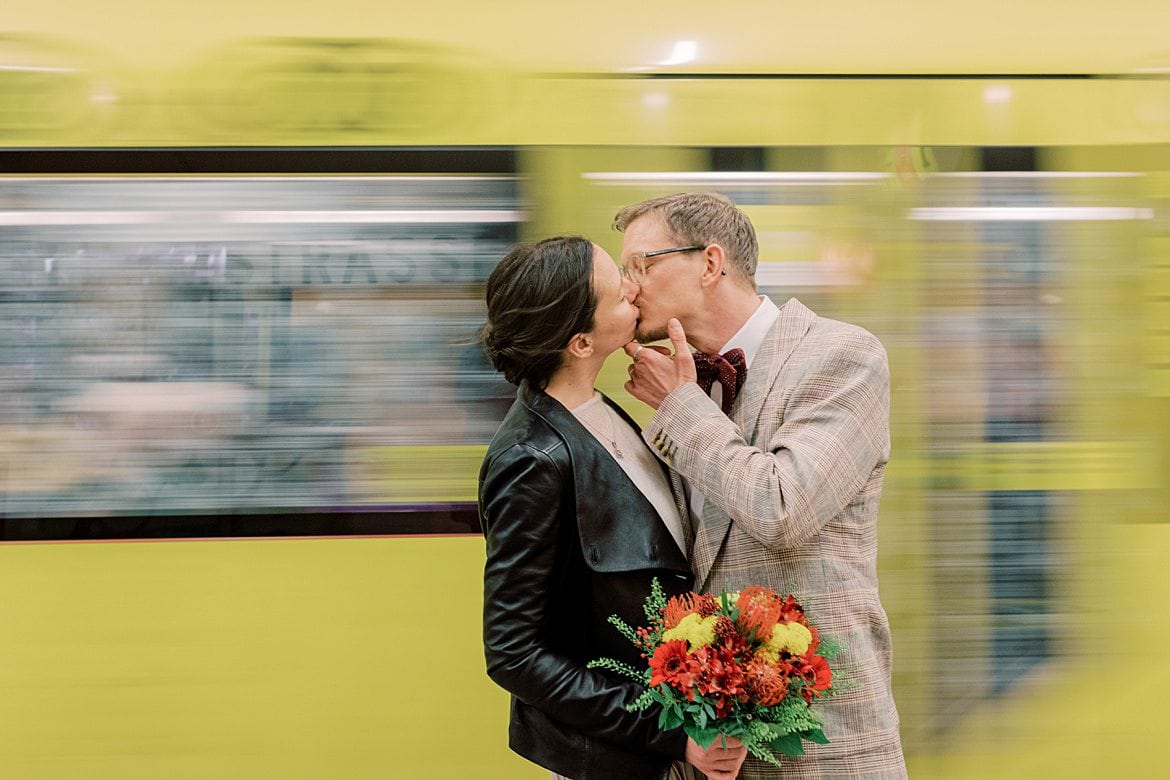 Brautpaar küsst sich vor einer fahrenden U-Bahn