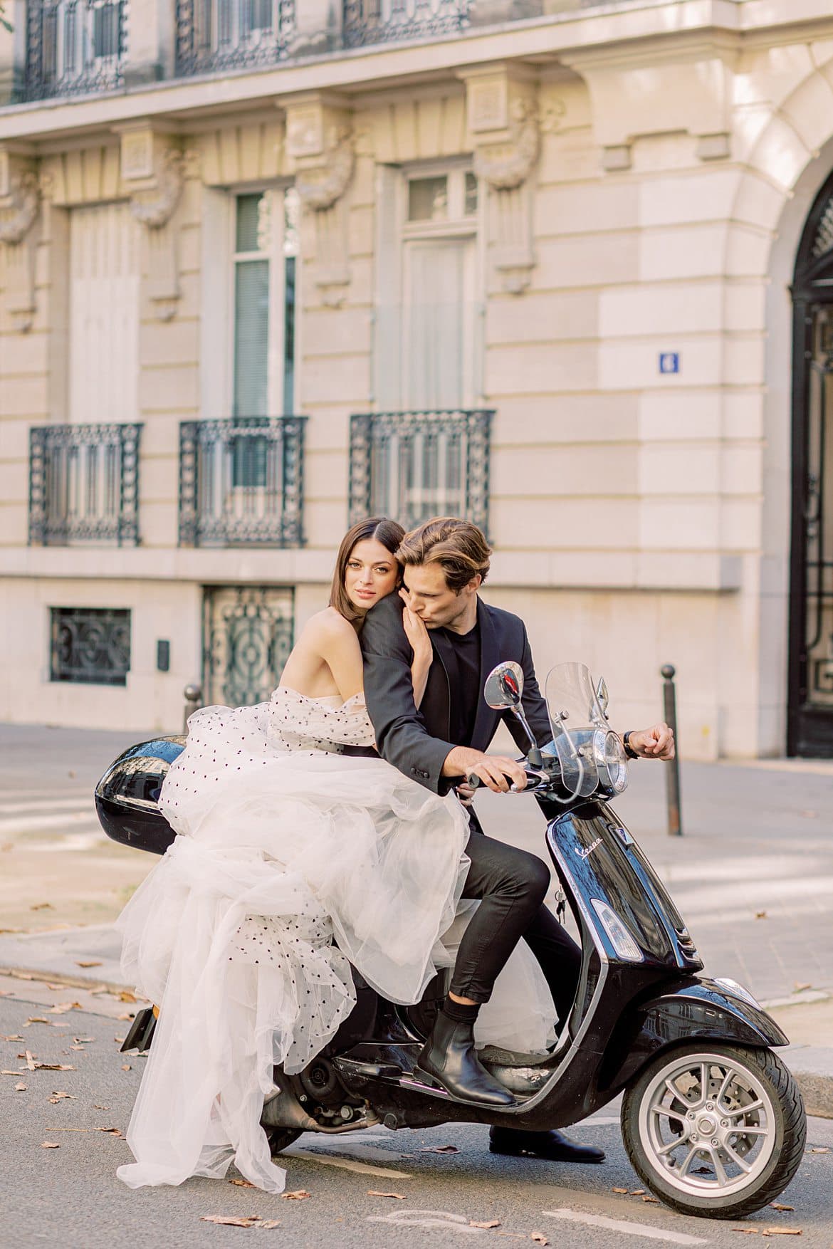 Paar sitzt auf einer Vespa in Paris