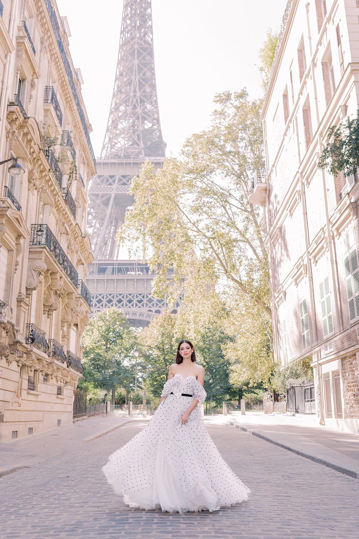 Portrait einer Frau im Ballkleid unter dem Eiffelturm in Paris