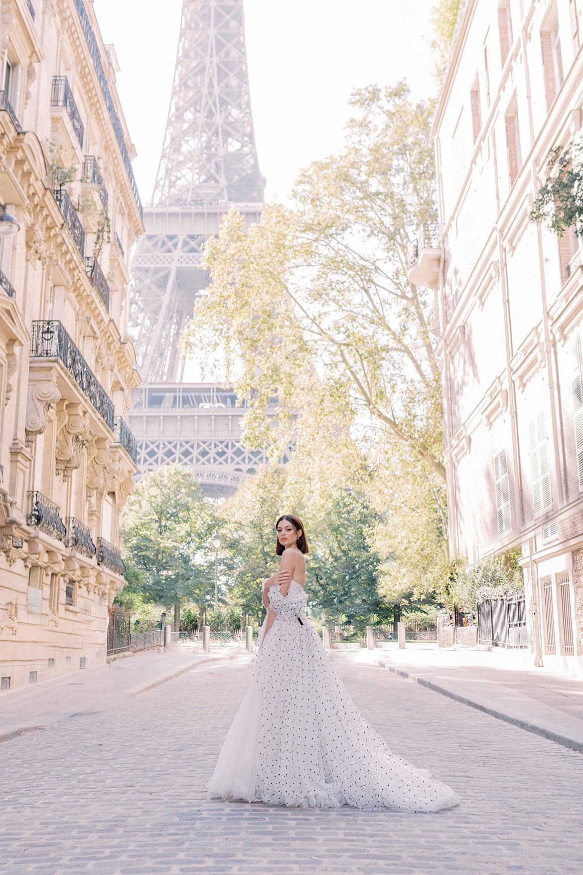 Portrait einer Frau im Ballkleid unter dem Eiffelturm in Paris