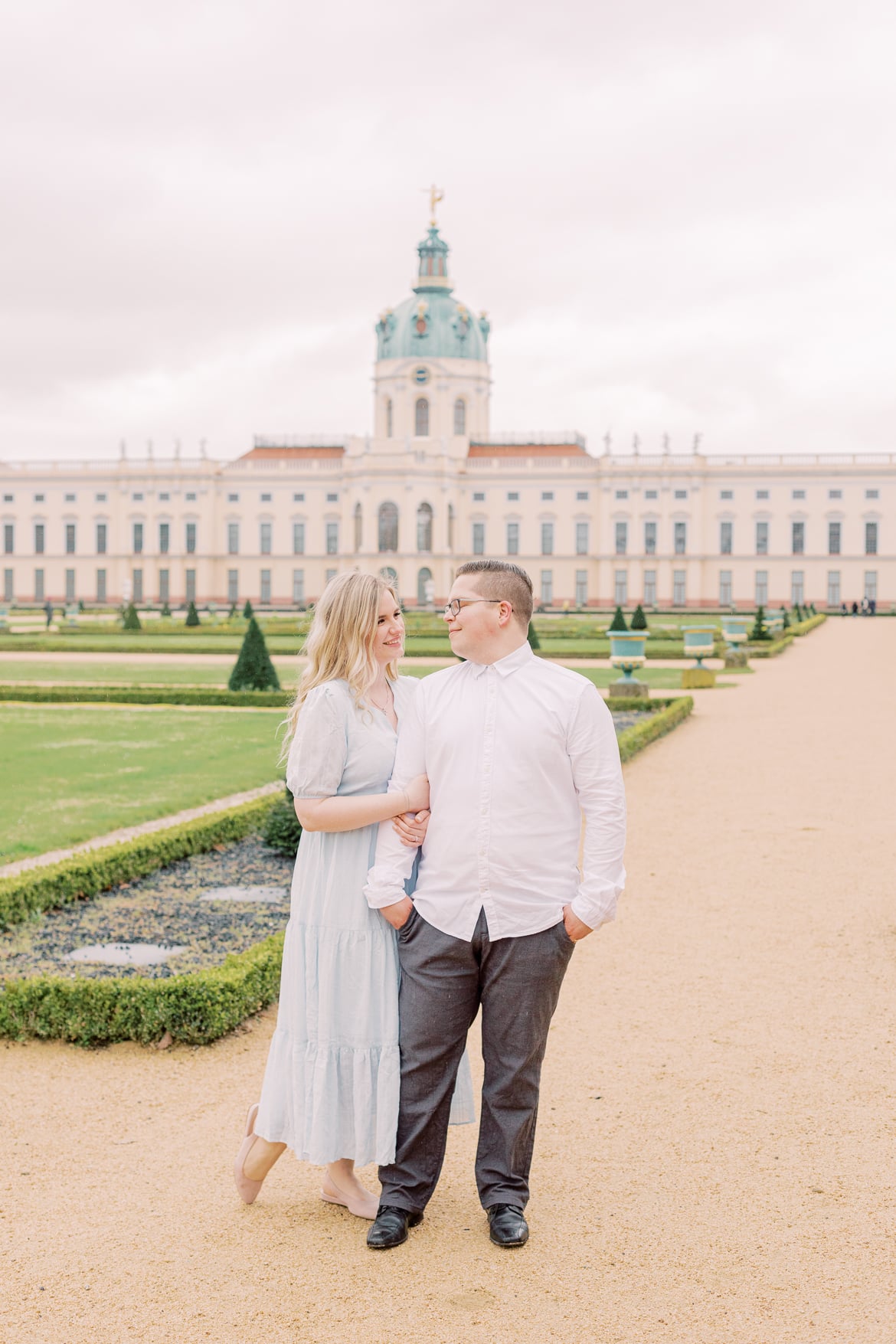 Ein Paar steht untergehakt im Park vom Schloss Charlottenburg