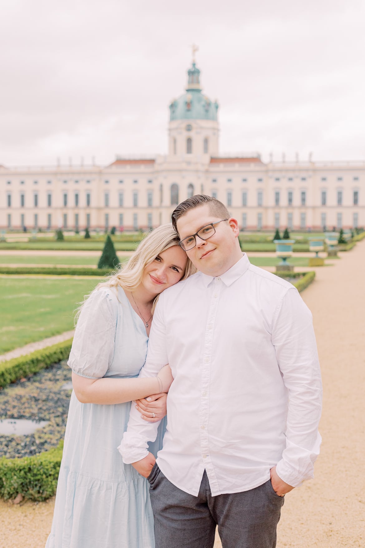 Ein Paar steht vor dem Schloss Charlottenburg im Park