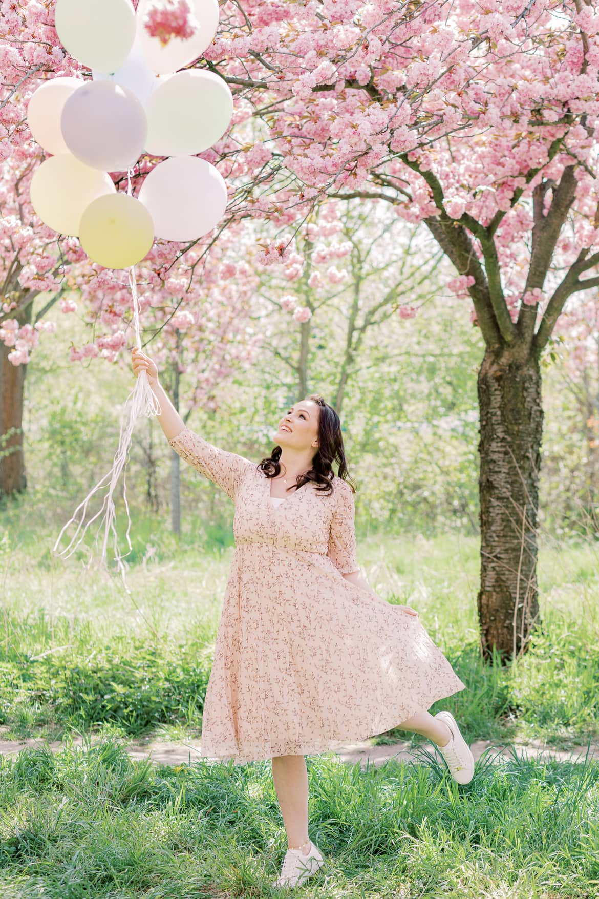 Eine Frau hat Luftballons in der Hand, es sieht aus als würde sie mit ihnen davonschweben