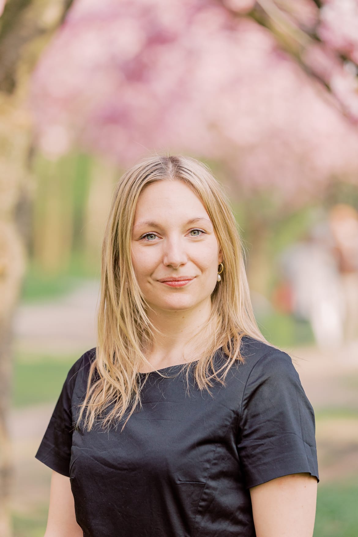 Portrait einer blonden Frau unter Kirschblüten