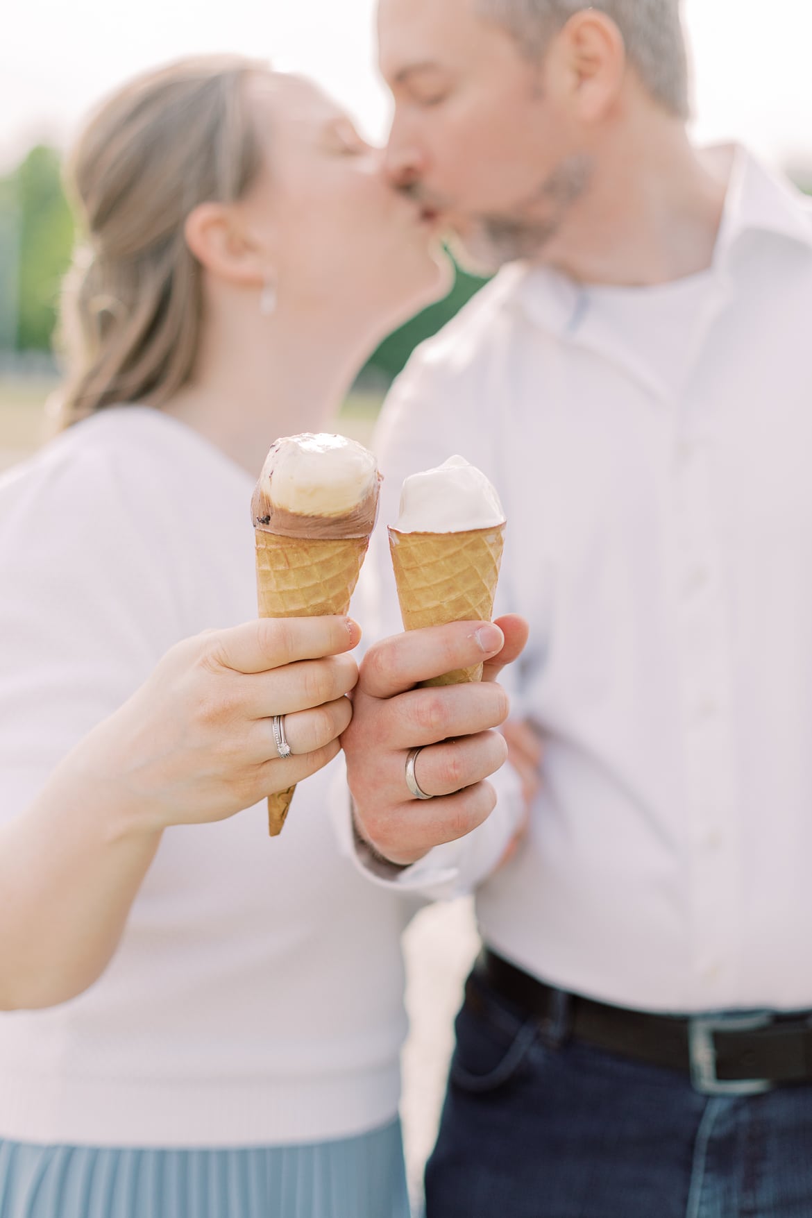 Ein Pärchen hält Eis in die Kamera und küsst sich dabei