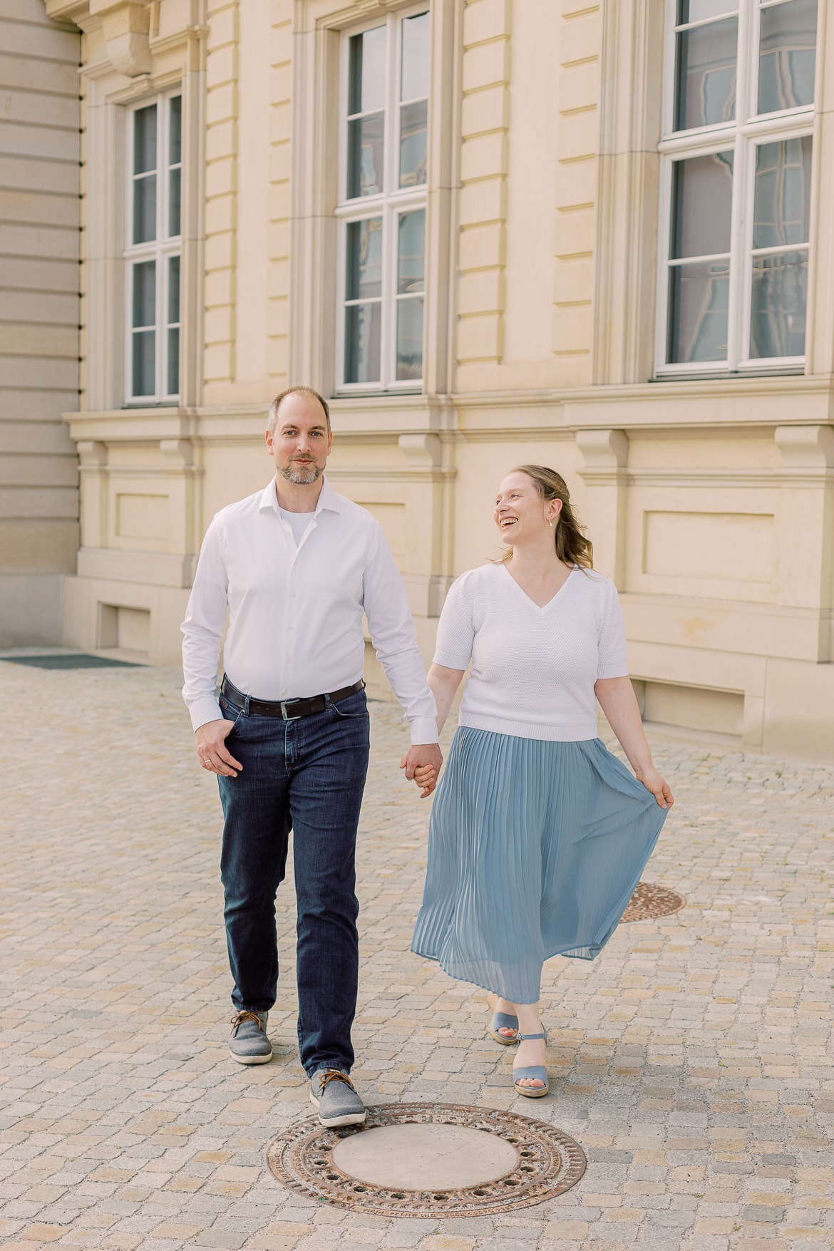 Ein Paar spaziert lachend vor dem Stadtschloss Berlin