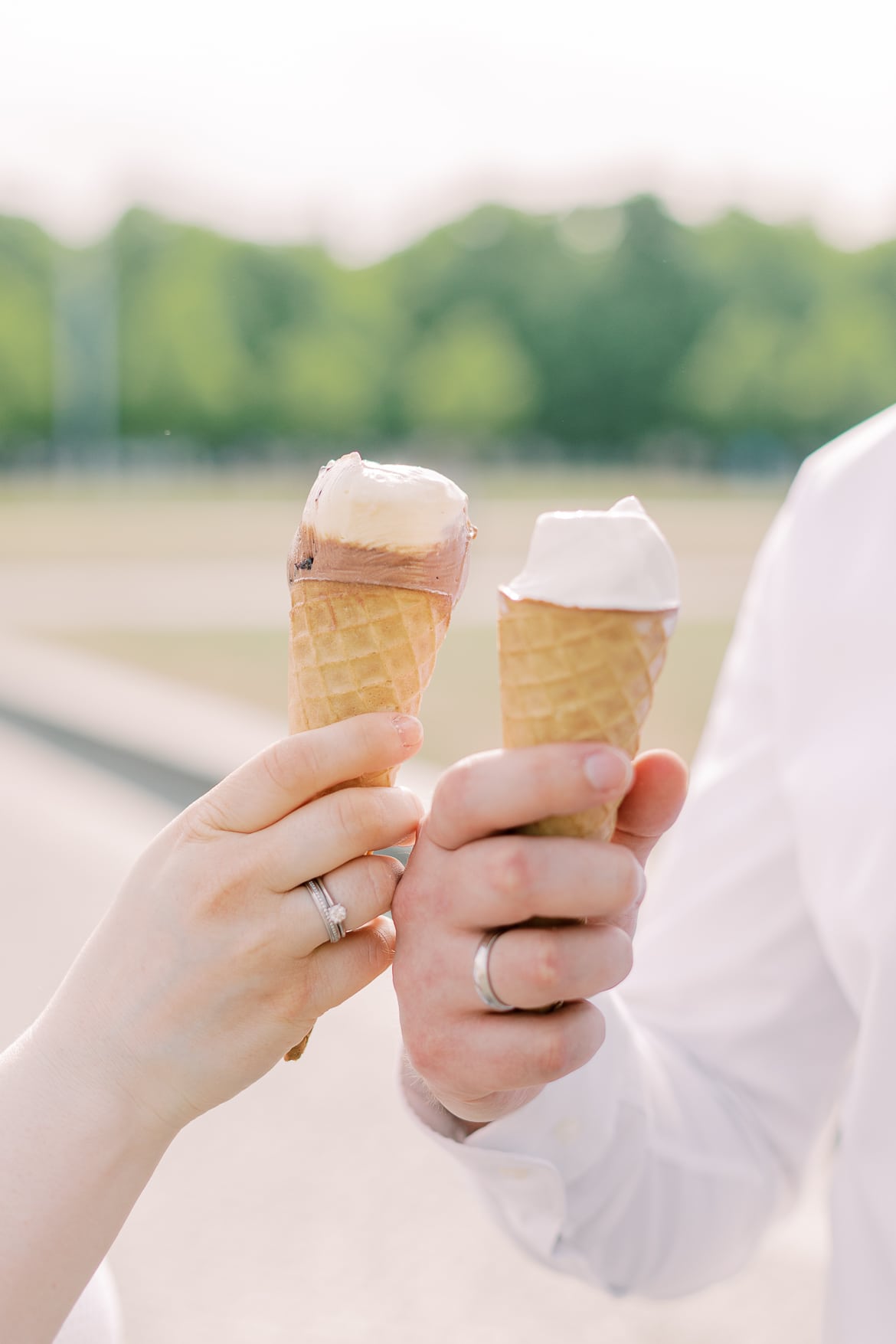 Ein Pärchen hält Eis fest, man sieht die Eheringe der beiden