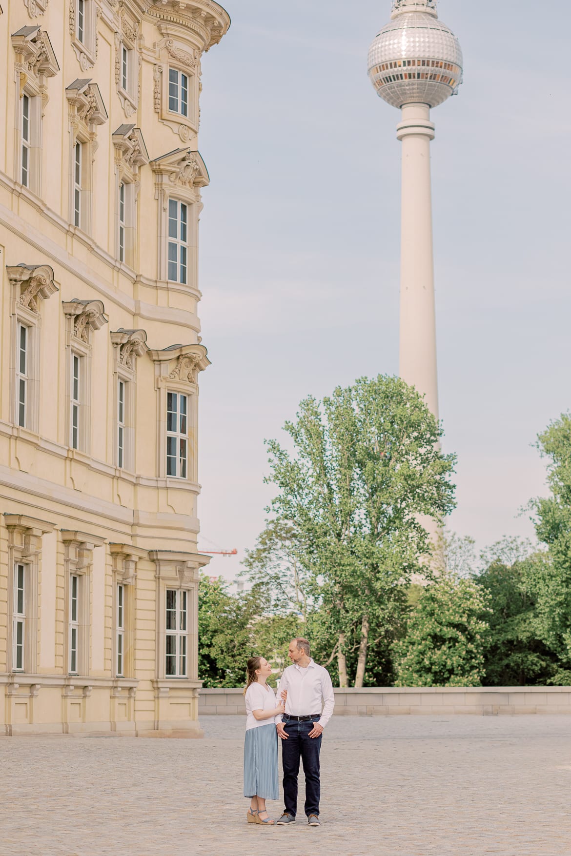 Ein Pärchen vor dem Berliner Stadtschloss mit dem Fernsehturm im Hintergrund