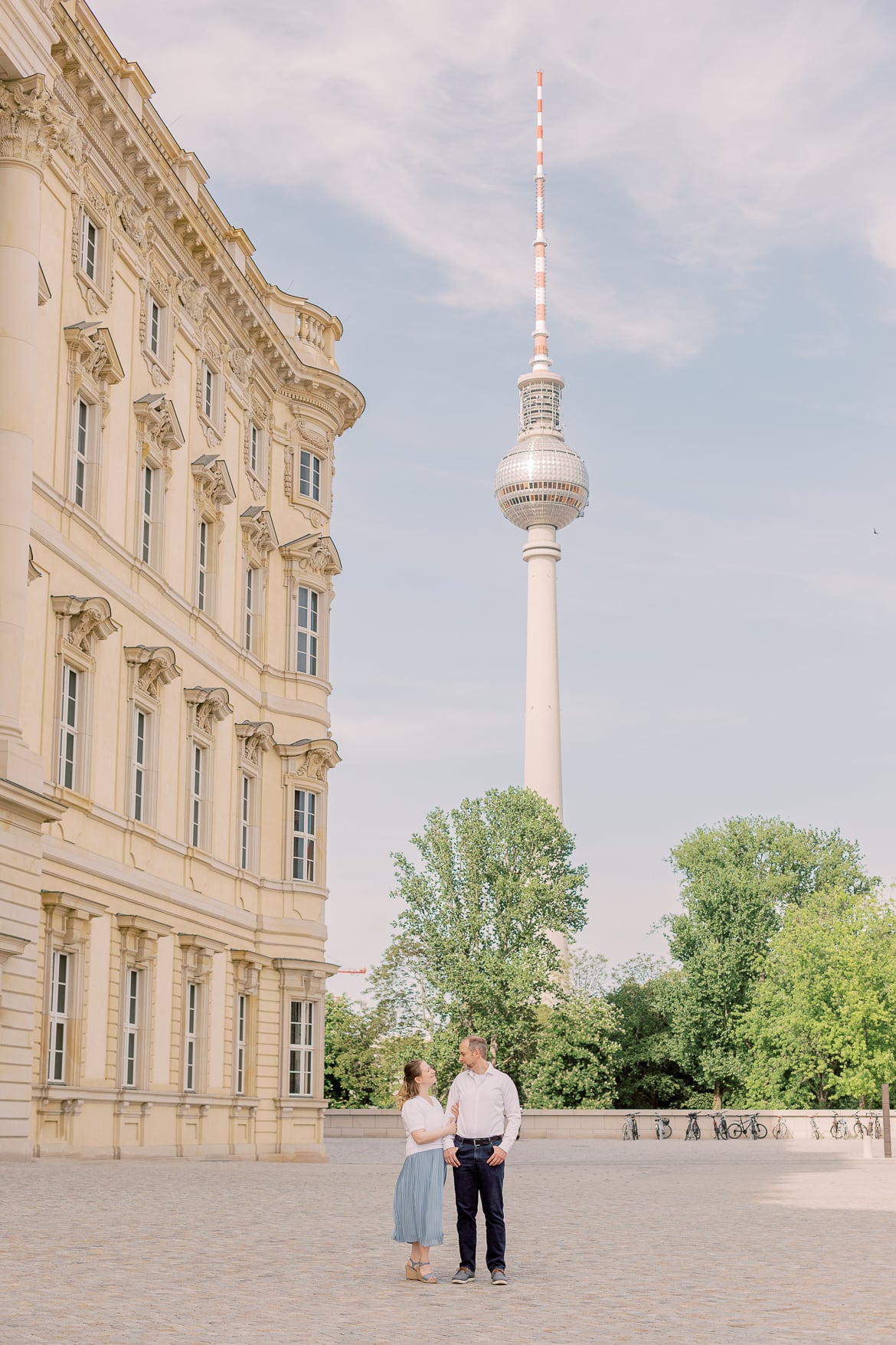 Ein Pärchen vor dem Berliner Stadtschloss mit dem Fernsehturm im Hintergrund