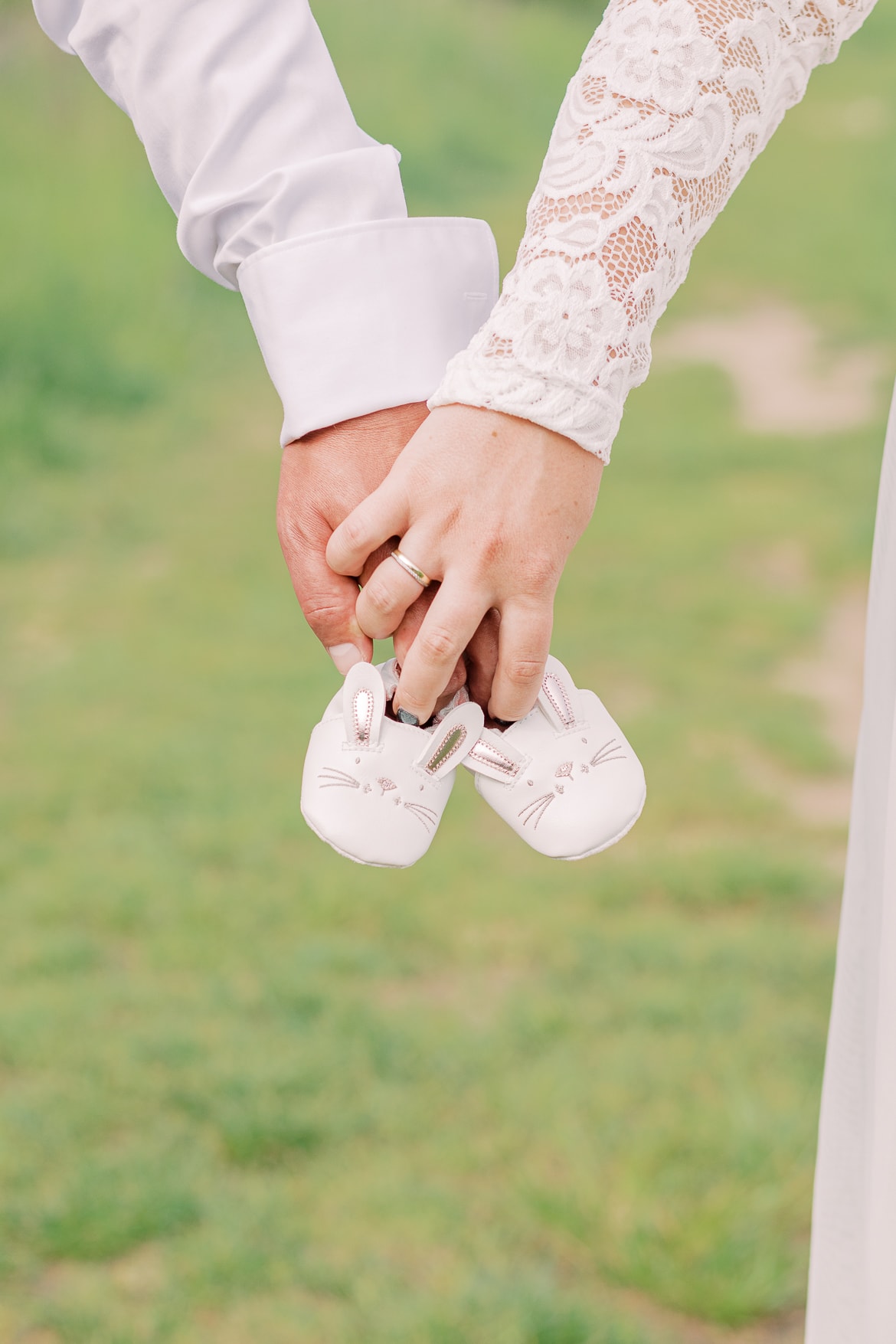 Ein Paar hält die Babyschuhe gemeinsam fest