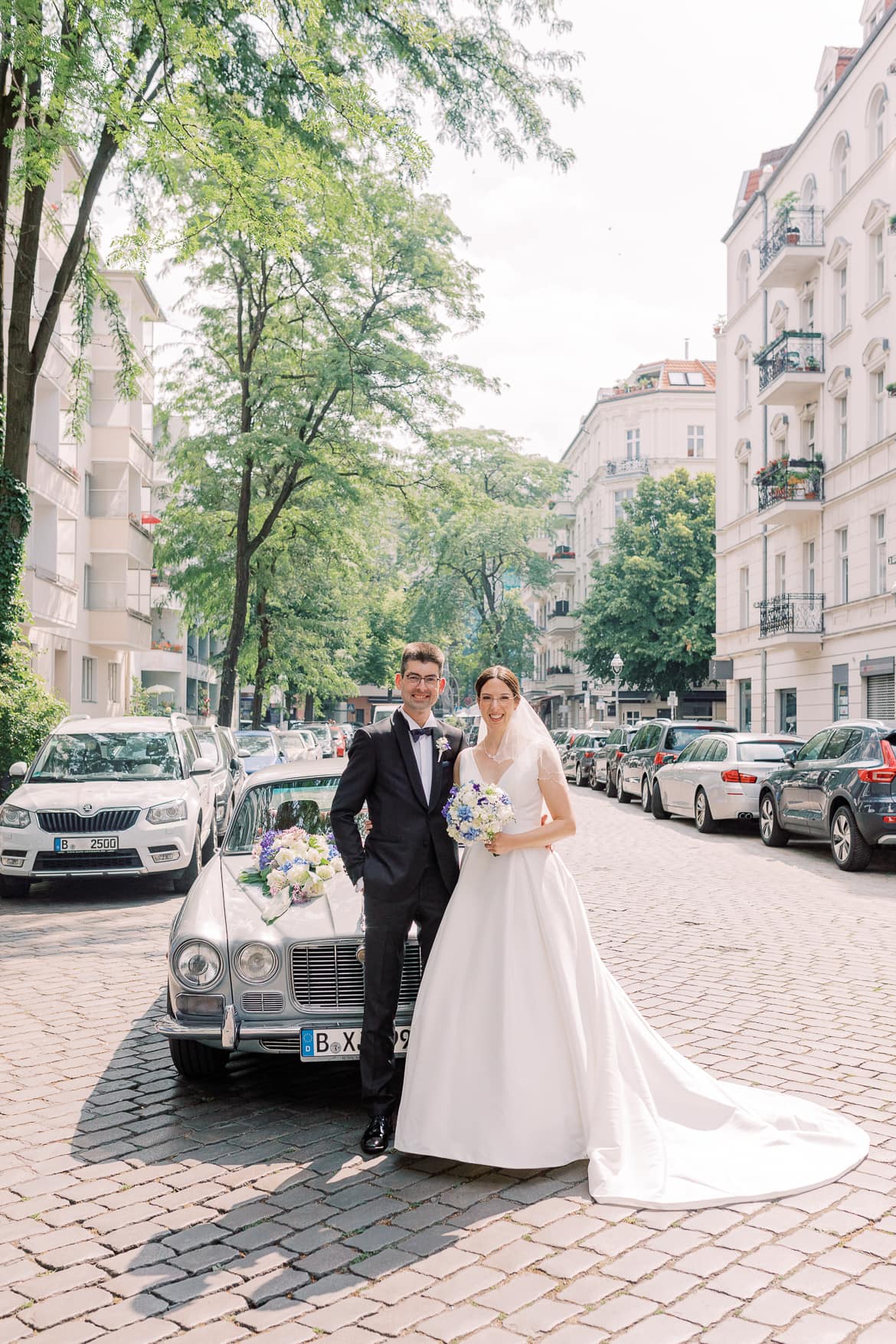 Brautpaar vor einem Oldtimer in einer Berliner Straße