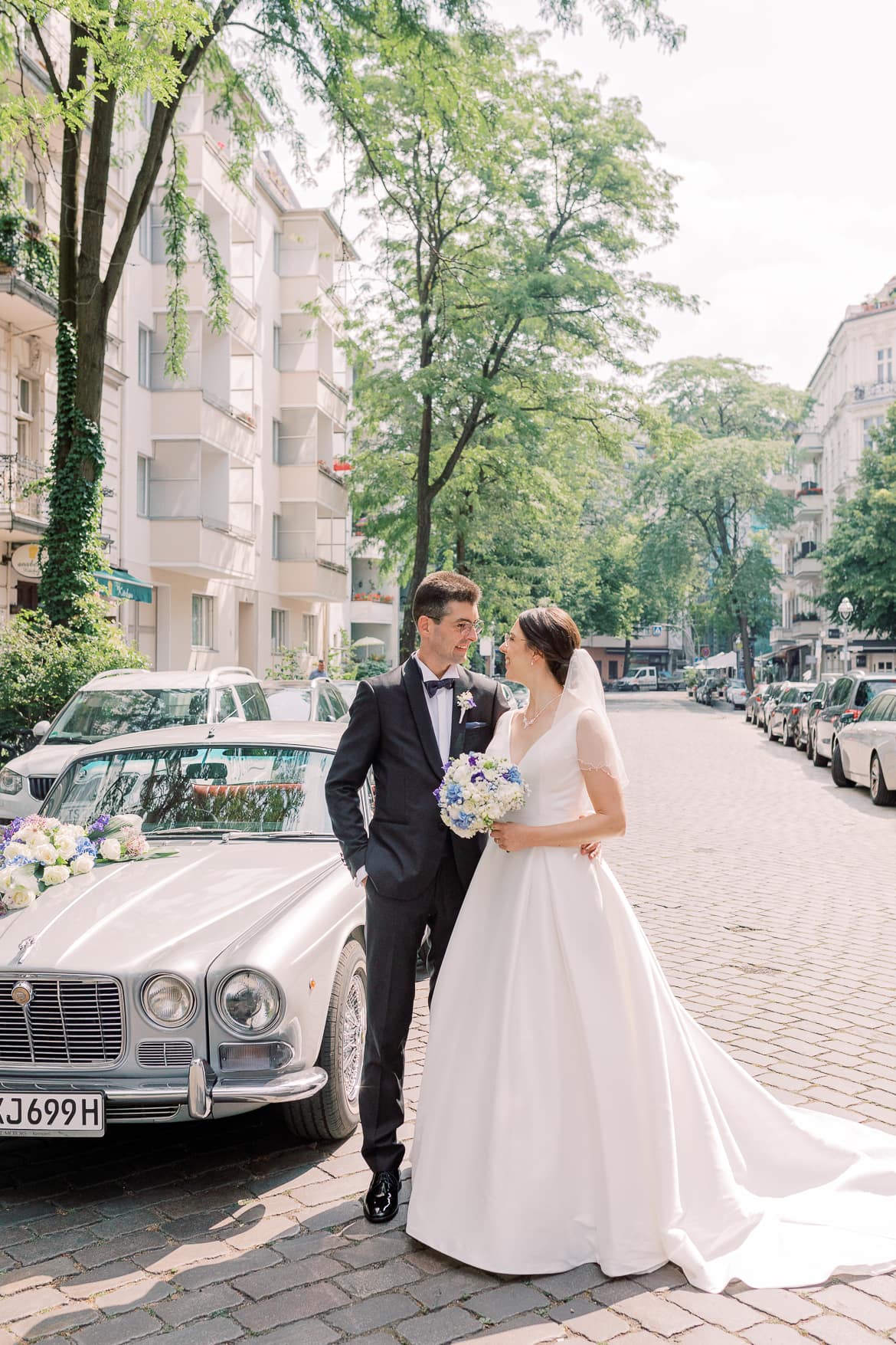 Brautpaar vor einem Oldtimer in einer Straße in Berlin