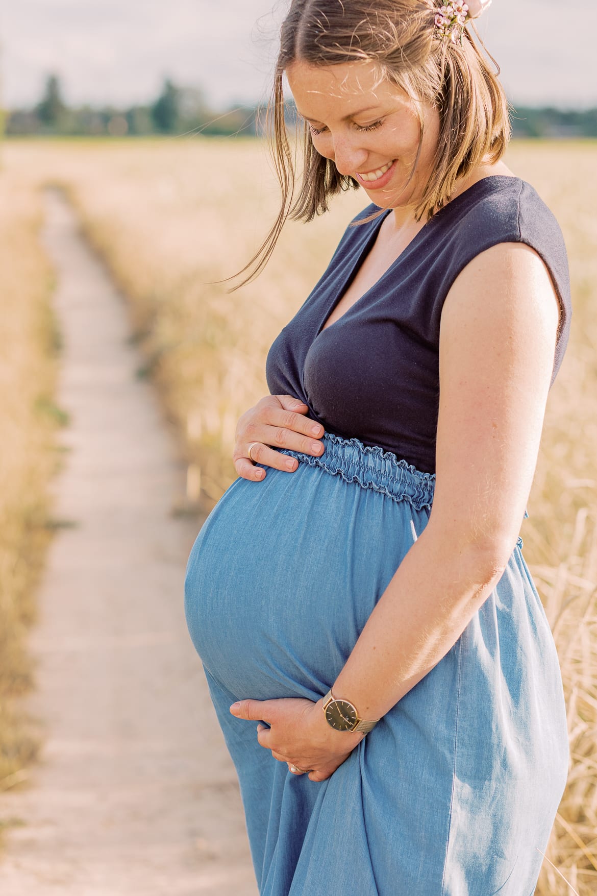 Babybauch Session zum Sonnenuntergang im Feld