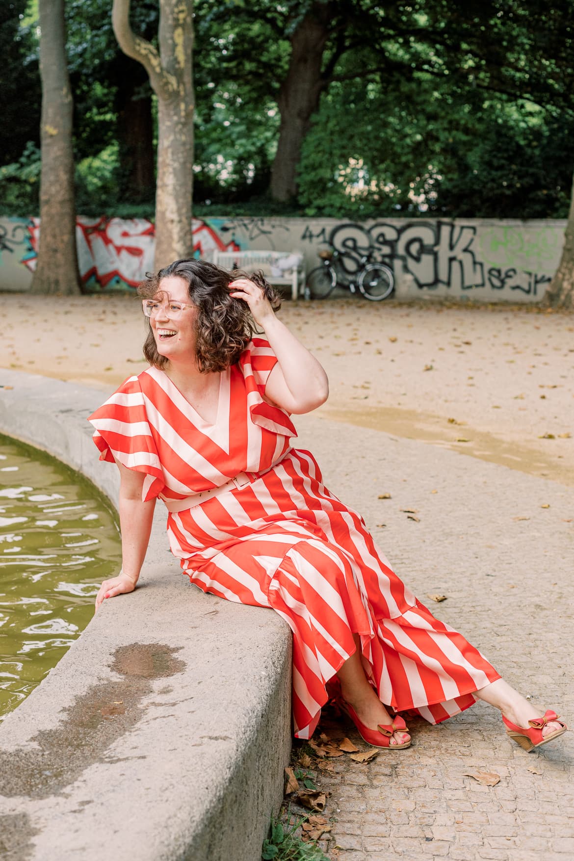 Eine Frau sitzt an einem Springbrunnen