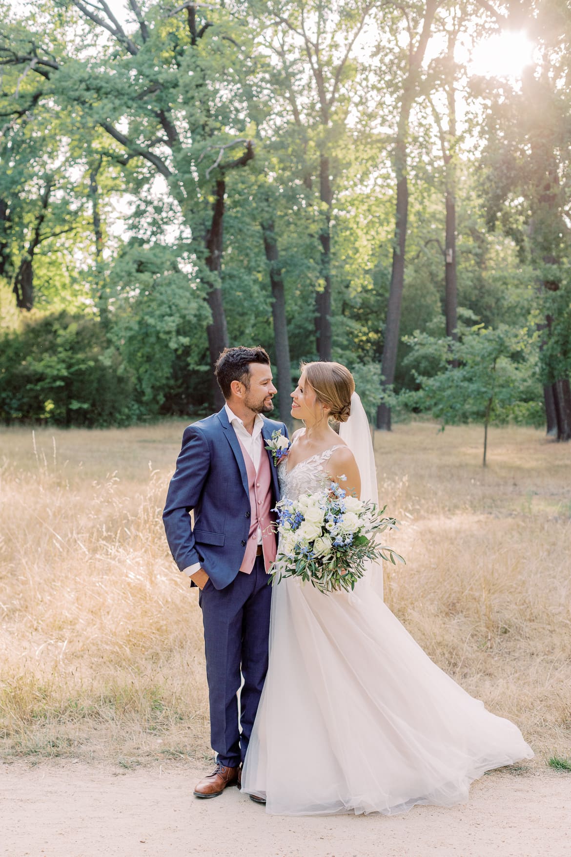 Hochzeitspaar im Park, welches sich anlächelt