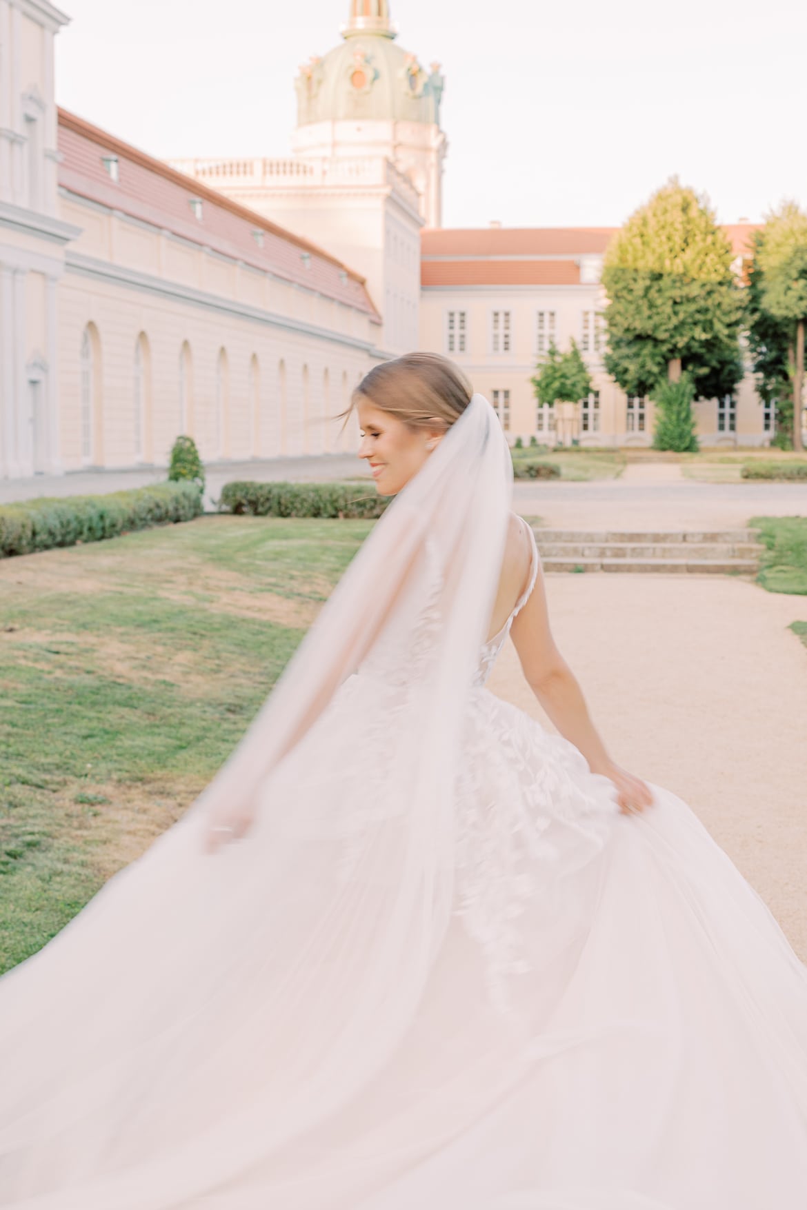 Braut tanzt im Park mit wehenden Kleid