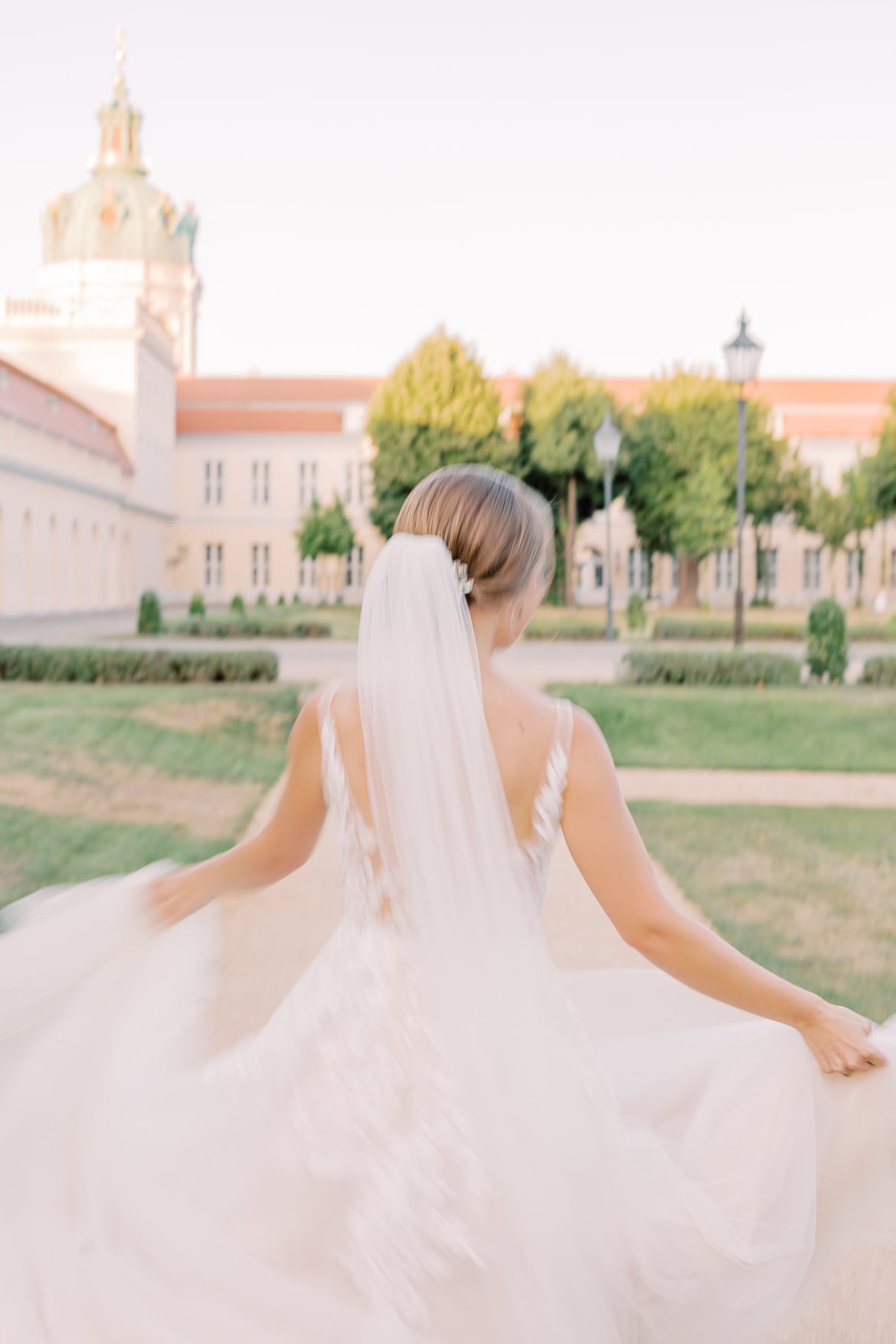 Braut rennt durch den Park mit wehenden Kleid