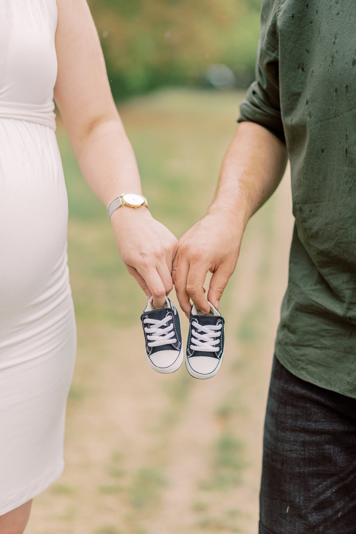 Zwei Hände halten ganz kleine Baby Turnschuhe