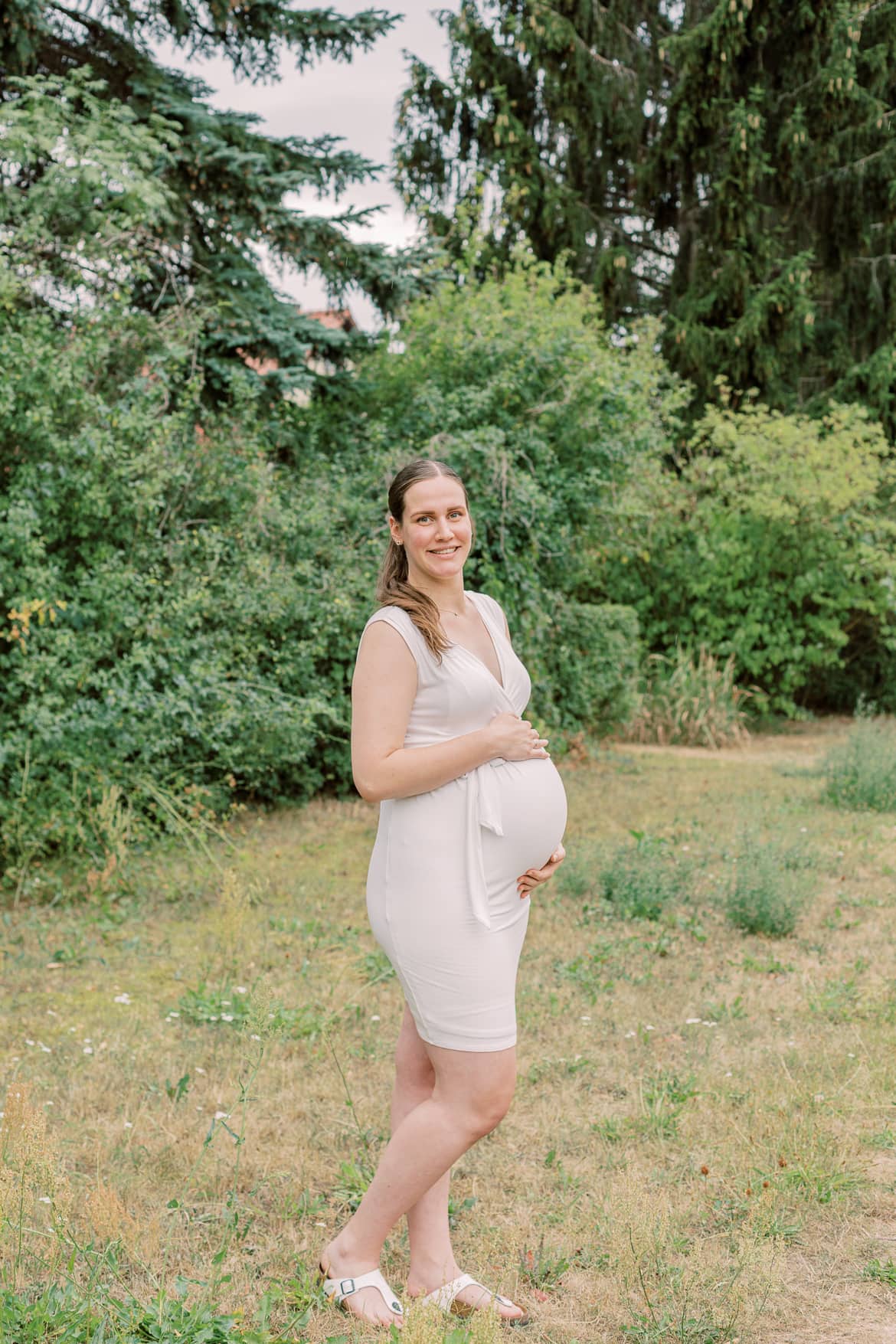 Eine schwangere Frau hält ihren Bauch