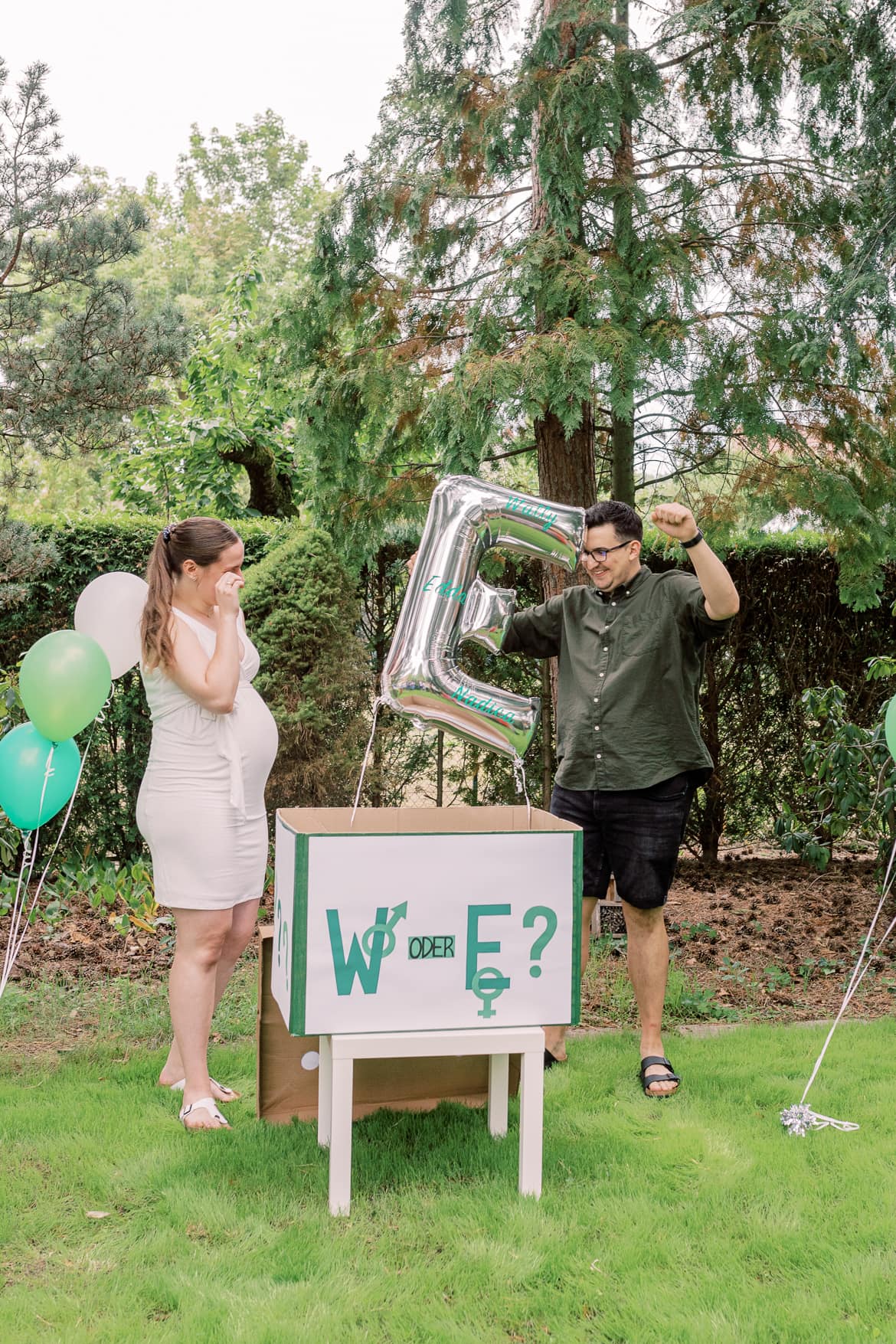 Eltern jubeln neben einem Helium Ballon