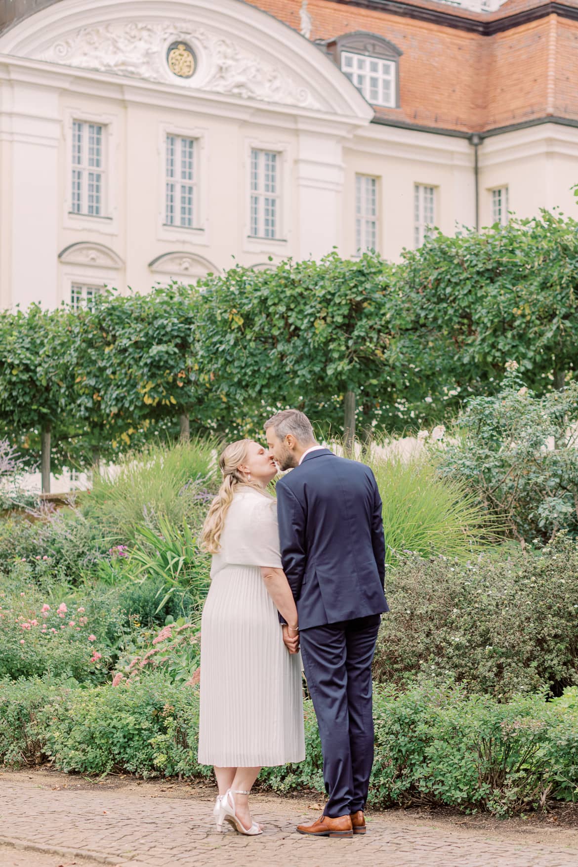 Hochzeitspaar küsst sich vor dem Schloss Köpenick berlin