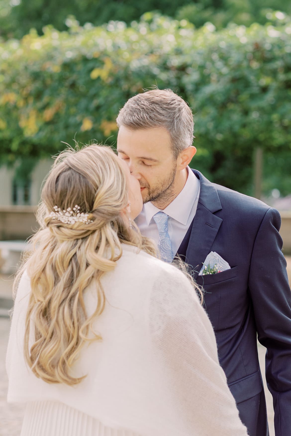 Hochzeitspaar küsst sich im Park