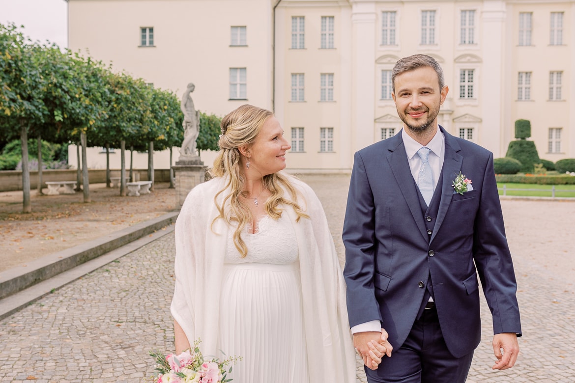 Hochzeitspaar spaziert vor dem Schloss Köpenick Berlin