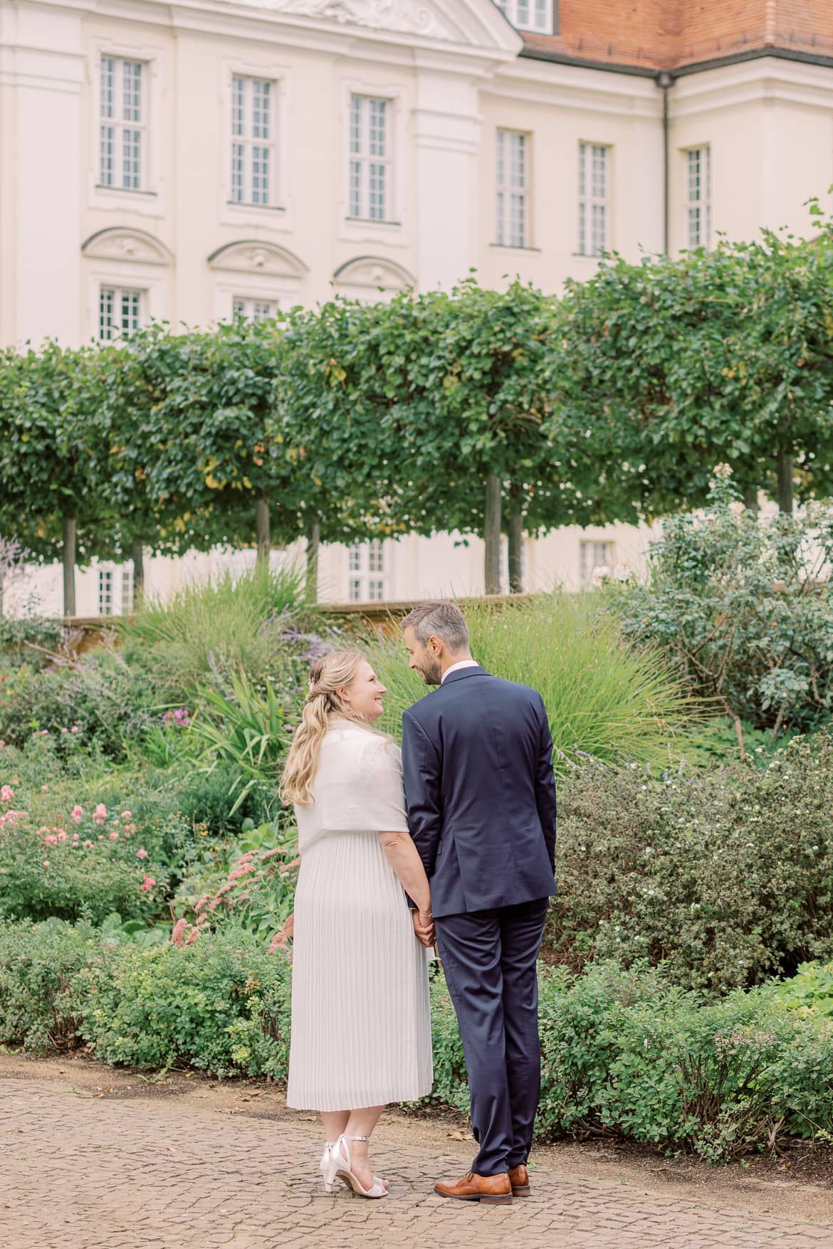 Hochzeitspaar kuschelt im Park des Schloss Köpenick Berlin