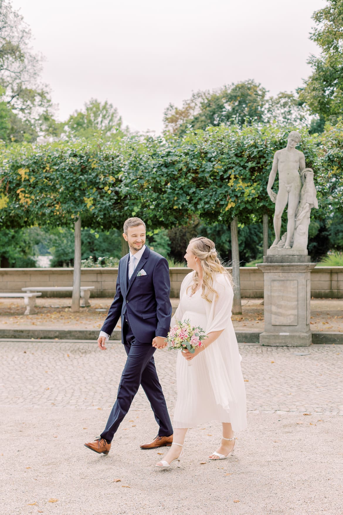 Hochzeitspaar spaziert in der Parkanlage des Schloss Köpenick Berlin