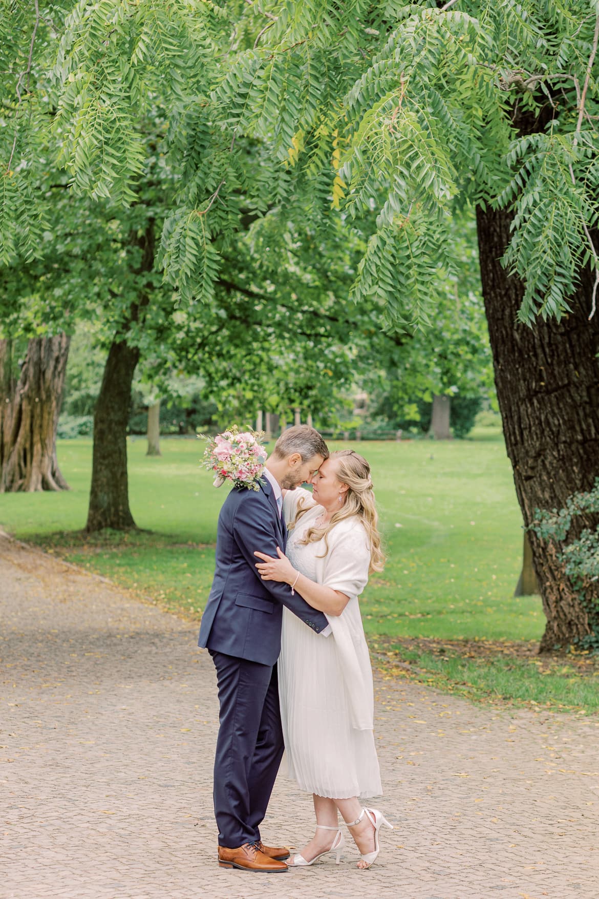 Hochzeitspaar umarmt sich unter einem Baum