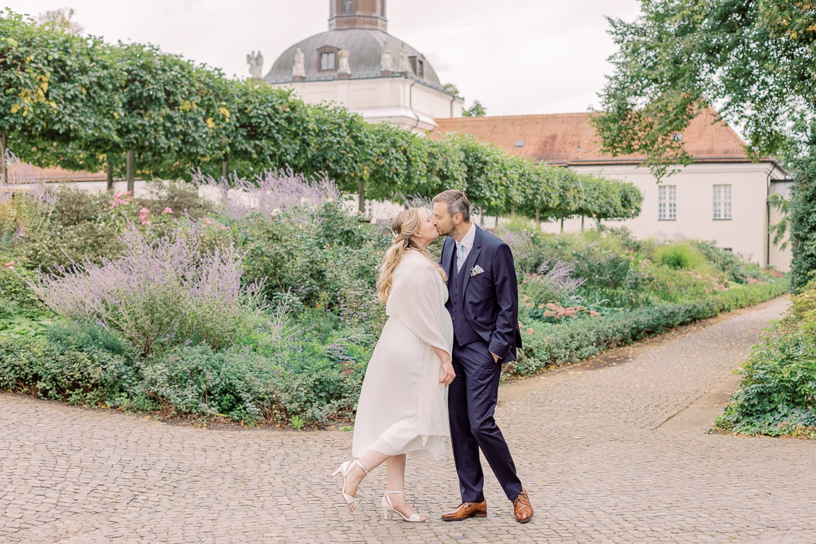 Hochzeitspaar küsst sich im Park des Schloss Köpenick Berlin