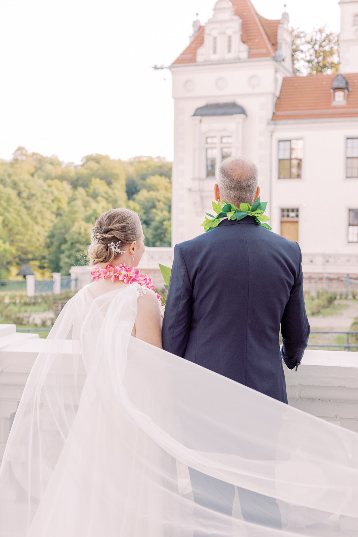 Hochzeitspaar schaut auf das Schloss Boitzenburg