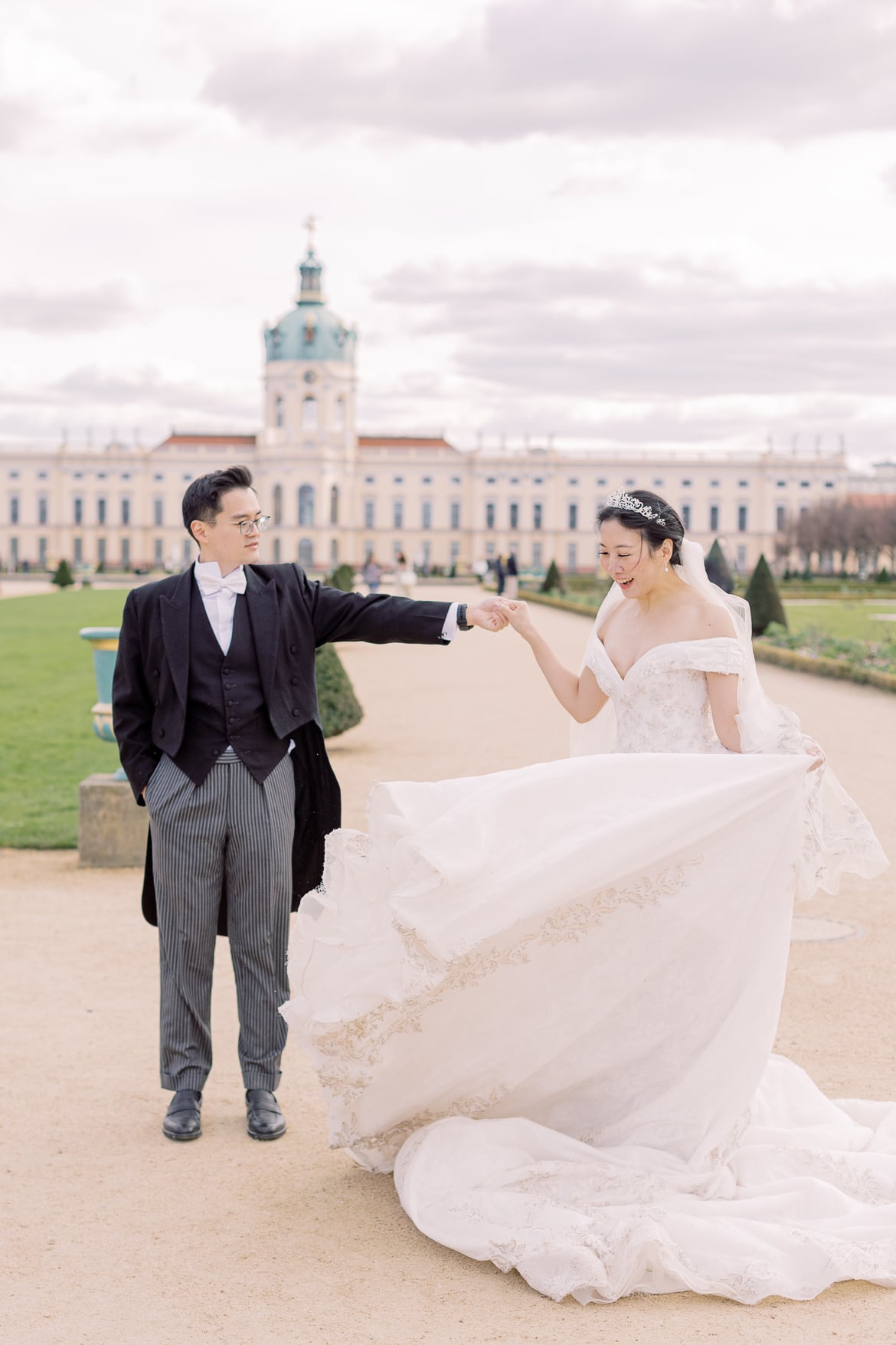 Hochzeitspaar tanzt im Park vor einem Schloss