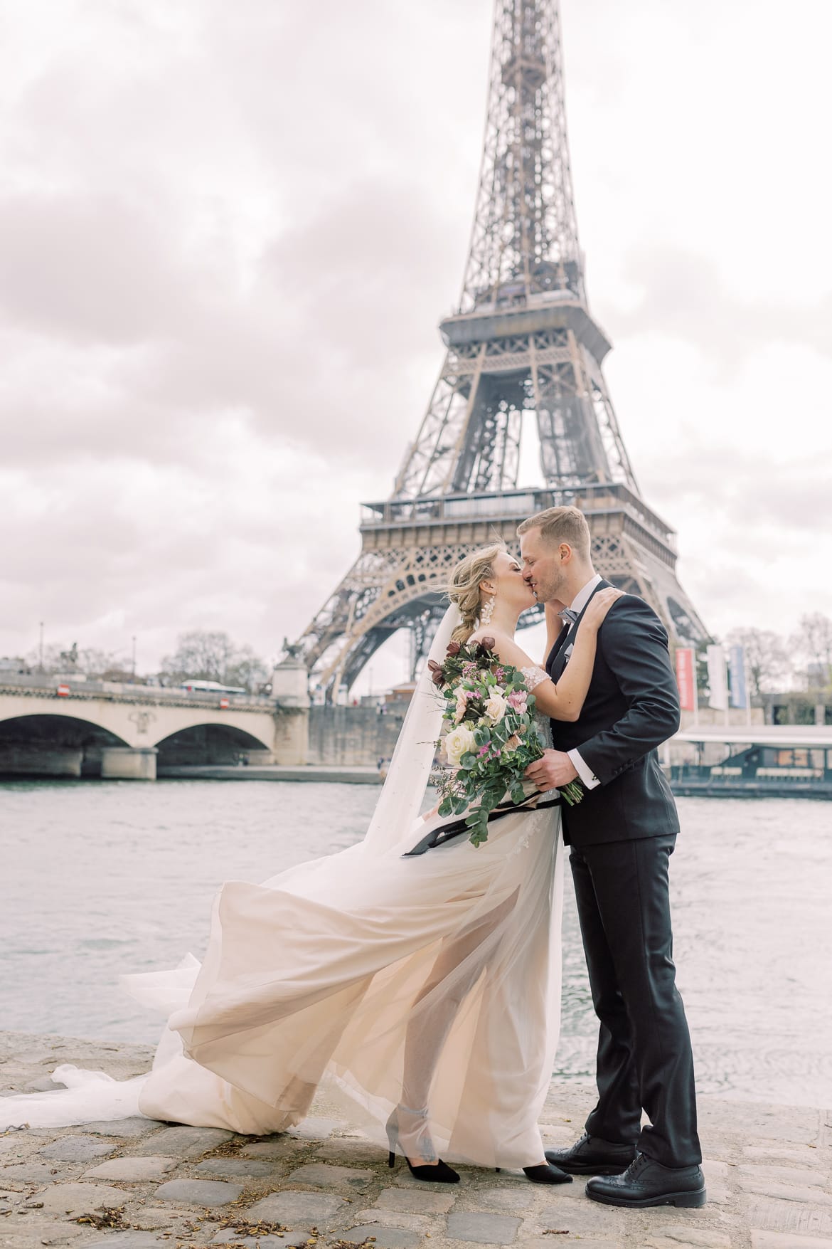 Hochzeitspaar vor dem Eiffelturm an der Seine in Paris