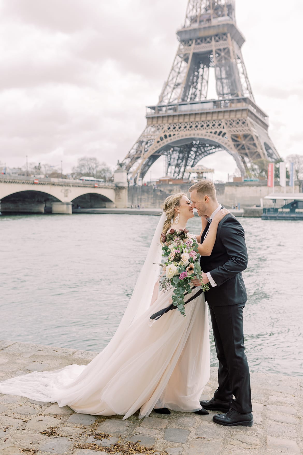 Hochzeitspaar vor dem Eiffelturm an der Seine in Paris