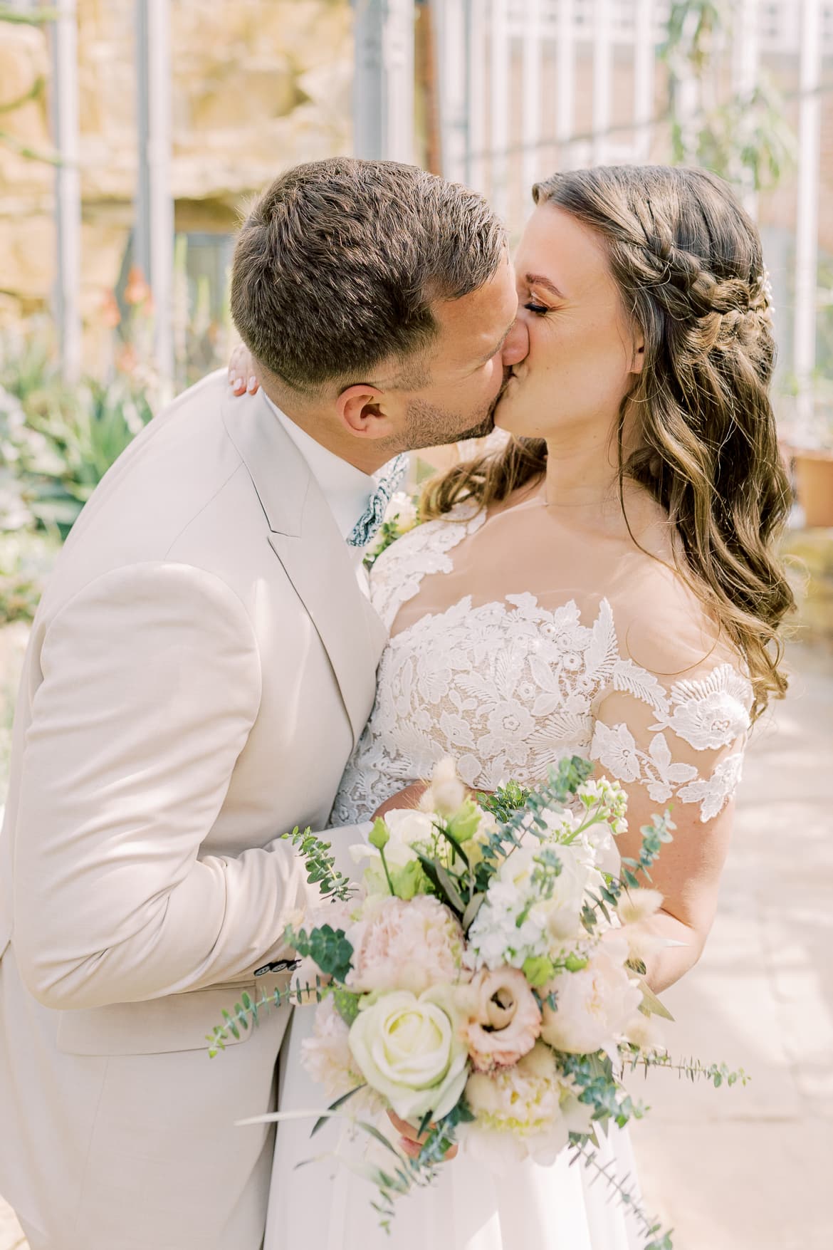 Hochzeitspaar küsst sich im Gewächshaus im Botanischen Garten Berlin