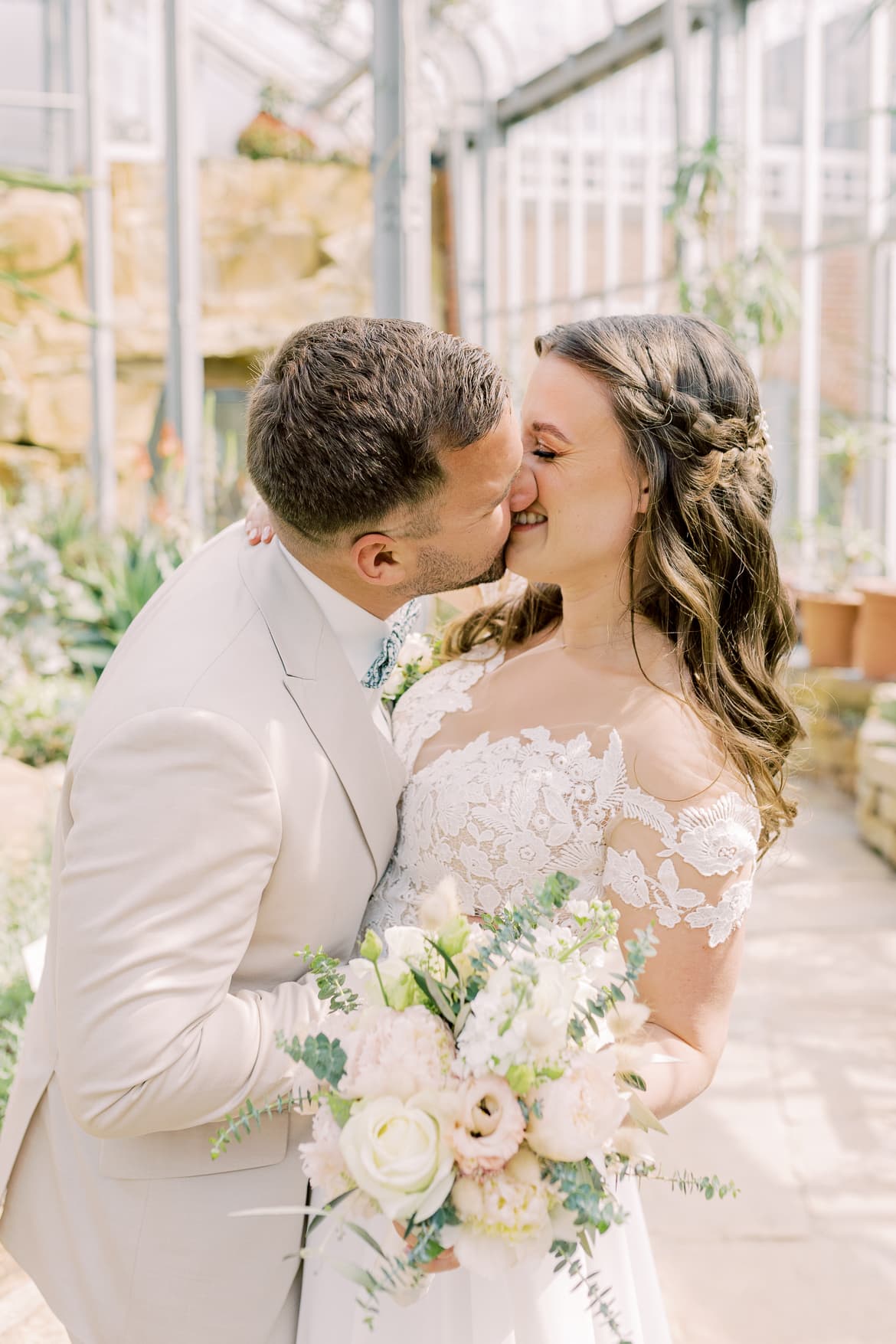 Hochzeitspaar küsst sich im Gewächshaus im Botanischen Garten Berlin