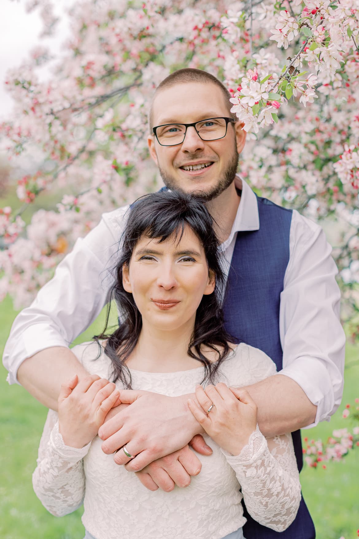 Hochzeitspaar vor einem blühenden Baum im Park