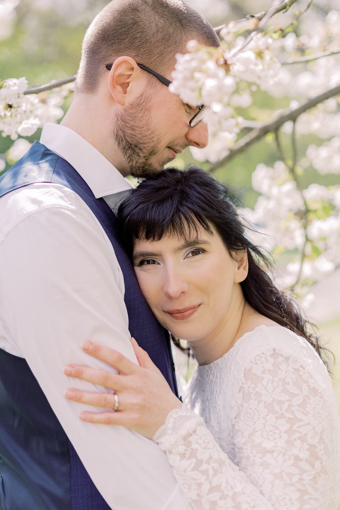 Hochzeitspaar vor einem blühenden Baum im Park