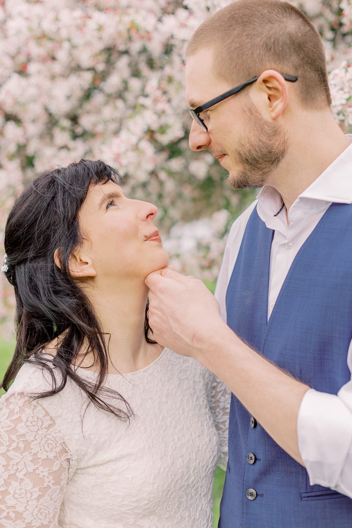 Hochzeitspaar vor einem blühenden Baum im Park