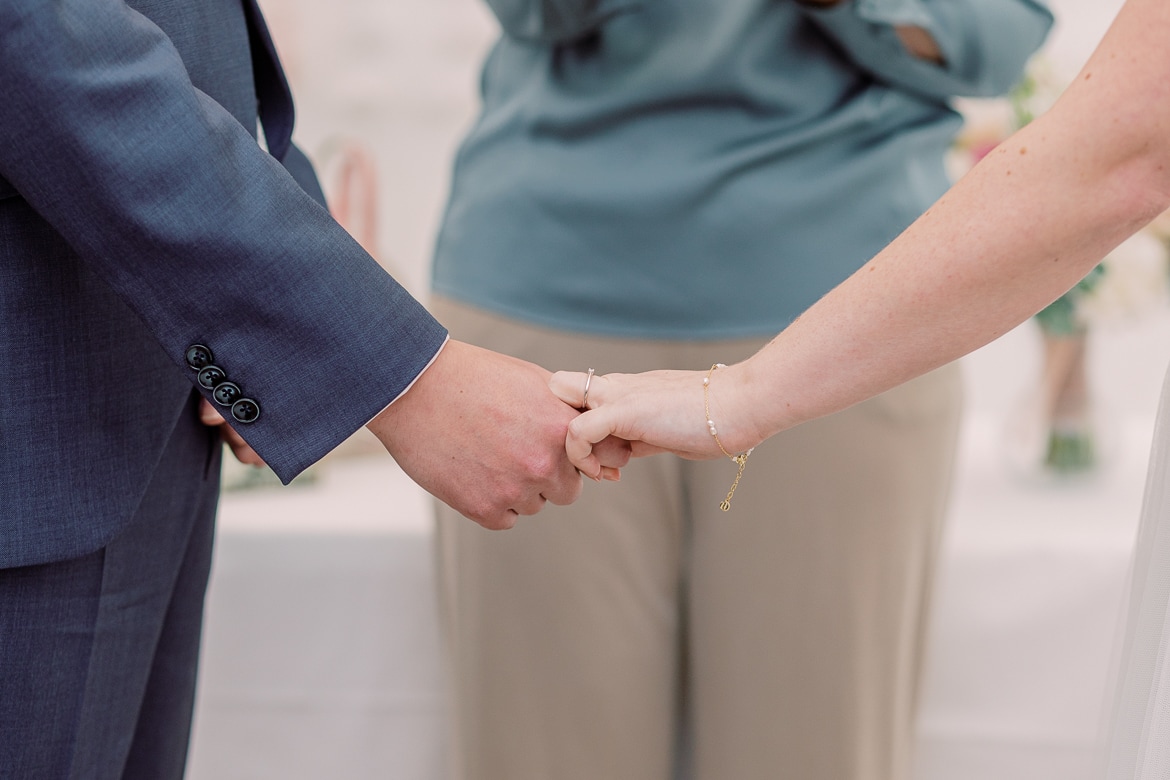 Hochzeitspaar hält sich an den Händen fest