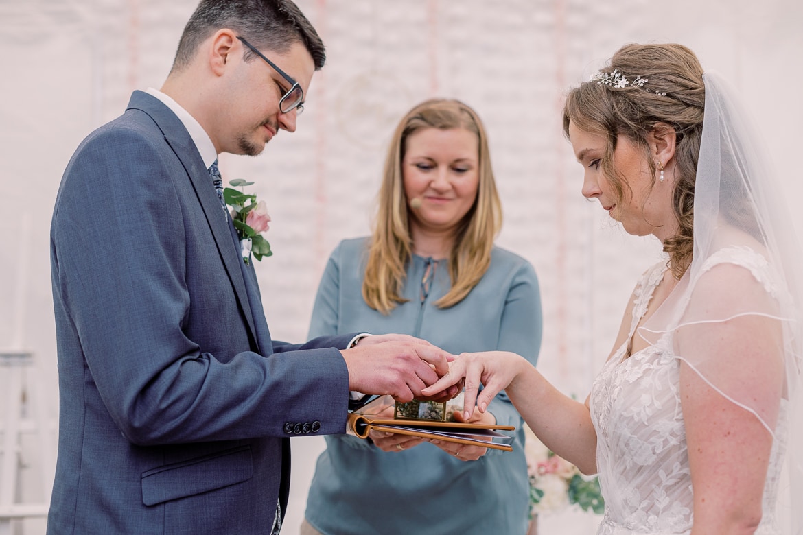 Hochzeitspaar steckt sich die Ringe an