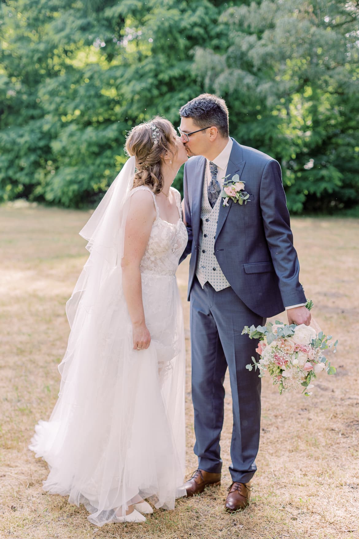 Hochzeitspaar küsst sich im Park