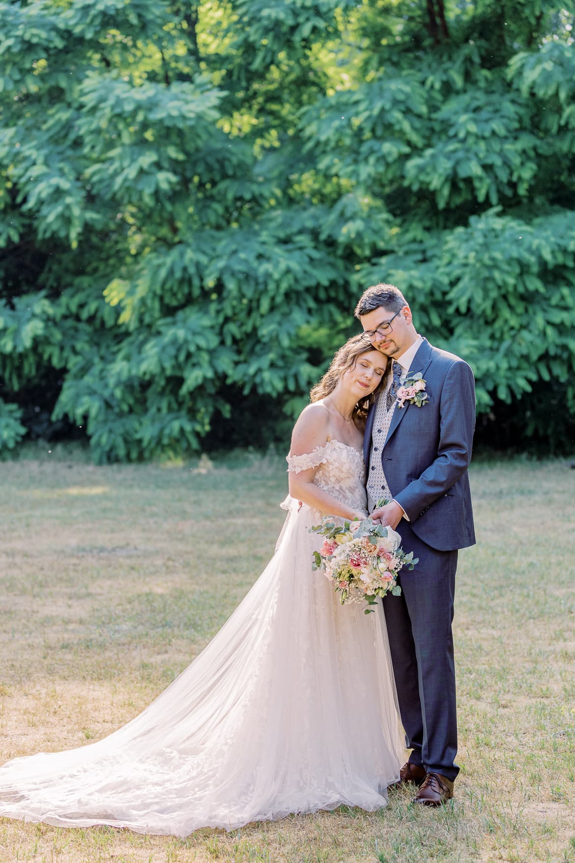 Hochzeitspaar kuschelt im Park